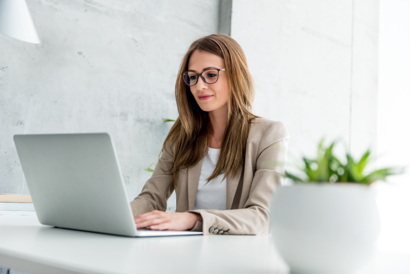 A woman smilling working with Juuzt AI chat on a PC